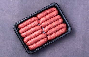 Raw beef sausages with rosemary and tomatoes photography . Top view