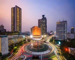 Selamat Datang monument at night with light trails in Jakarta city at dusk, Jakarta, Indonesia