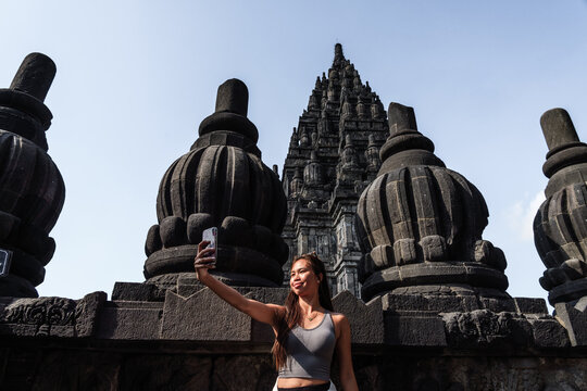 Asian woman taking a selfie at Prambanan temple, Yogyakarta, Java, Indonesia