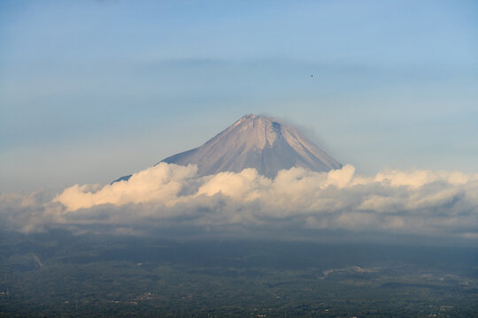 Mount Merapi active volcano emerging from the clouds, Yogyakarta, Central Java, Indonesia