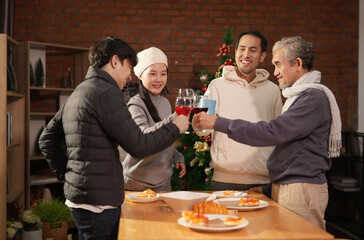 happy asian family celebrate new year party indoors at home,having meals,clinking a drink,smiling,conversation together