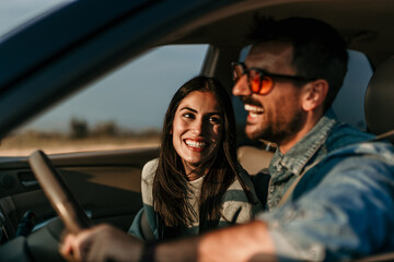Romantic sunset drive. Smiling couple on a road trip adventure