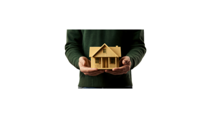 A person is holding a small house in their hands. The house is made of wood and has a white roof. The person is wearing a sweater and he is holding the house with care. transparent background