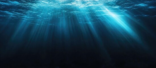 Mysterious dark underwater background with vibrant rays of light creating an ethereal atmosphere perfect for overlaying text or graphics.