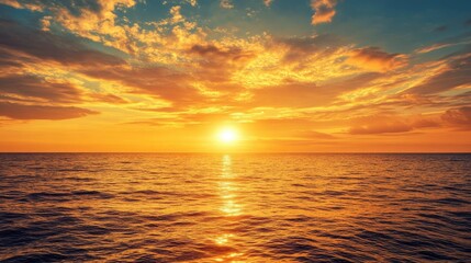 Obraz premium Stunning golden sunset over calm ocean waters with vibrant clouds reflecting on the surface in a serene nature scenery