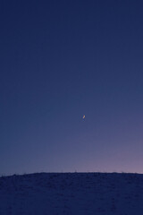 The crescent moon above the cultural landscape of rural Toten, Norway, in January 2025.
