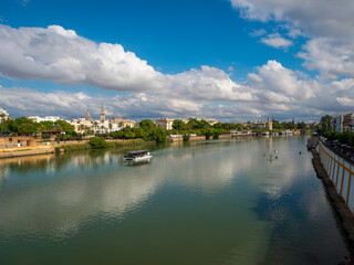 The Canal de Alfonso X111 in Seville, Spain from the Puente de Triana bridge looking towards the Cathedral and La Giralda belltower. Space for text.
