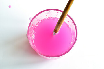 A glass of water in which a brush was washed on a white background.
