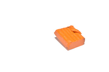 A piece of orange plasticine lies on a PNG background.