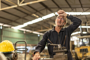 Senior worker tired exhausted headache pain suffer from hard work in heavy industry factory.