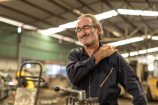 Senior worker tired exhausted muscle body pain suffer from hard work in heavy industry factory.