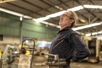 Senior worker tired exhausted muscle body pain suffer from hard work in heavy industry factory.