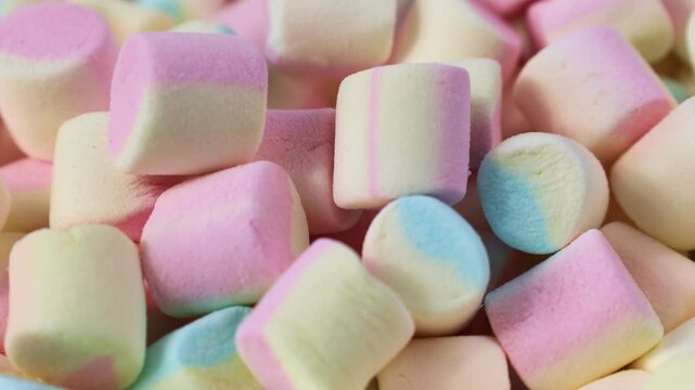 Colorful tasty sugar marshmallow candy pieces falling down close up
