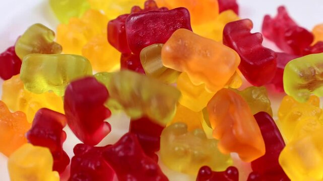 Bright colorful jelly gummy bears falling down close up