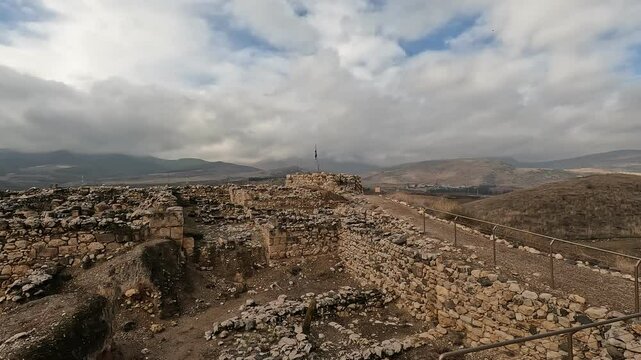 Ruins of the ancient fortress at Tel Hazor, a UNESCO World Heritage Site in northern Israel's Galilee, set against dramatic cloudy skies- Israeli winter.