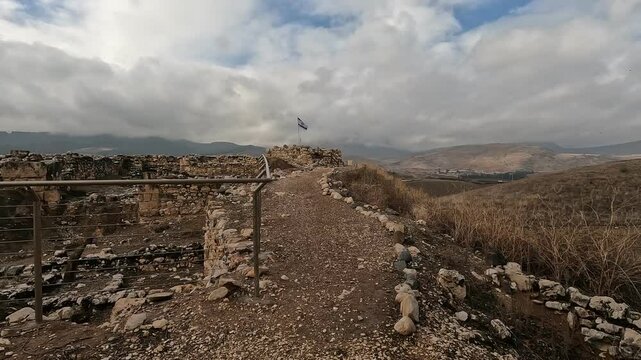Ruins of the ancient fortress at Tel Hazor, a UNESCO World Heritage Site in northern Israel's Galilee, set against dramatic cloudy skies.