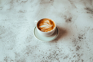 Minimalist Cup of Latte with Artful Foam Design on Textured Table
