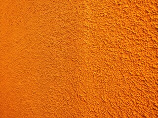 Naklejka premium Vibrant orange wall texture, perfect for home decor, offers a lovely abstract backdrop for design projects.