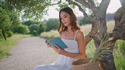 Focused woman writing notebook in notebook at summer vacation. Rural girl noting