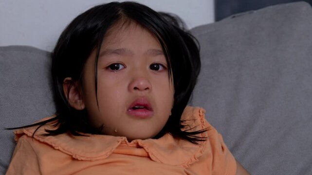 A Litter Asian girl sitting in room conner and crying after Punished by the blackout.