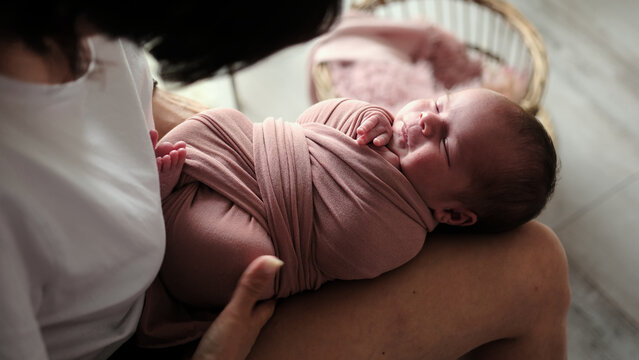 Newborn Photographer Swaddles A Baby During A Studio Photoshoot