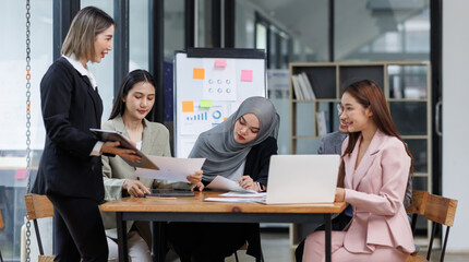 Happy asian business woman executive ceo leader discussing project management planning strategy working with diverse colleagues company team at office corporate board group meeting.
