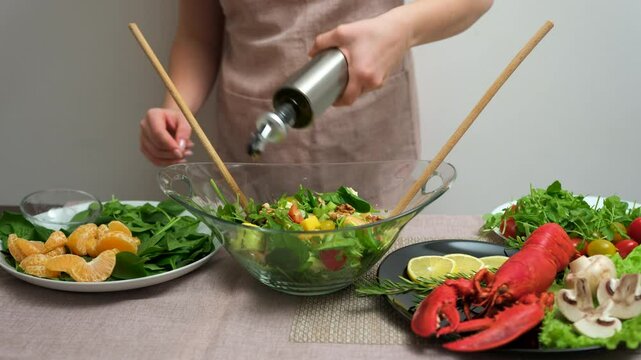 add olive oil to salad seafood lobster Hands only Caucasian home kitchen counter slicing organic fresh salad vegetables wireless tablet recipe healthy lifestyle eating