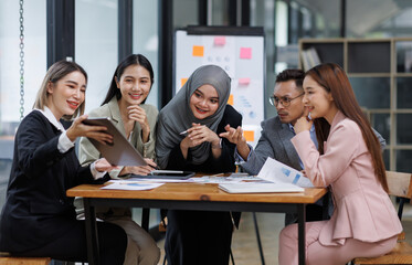 Happy asian business woman executive ceo leader discussing project management planning strategy working with diverse colleagues company team at office corporate board group meeting.

