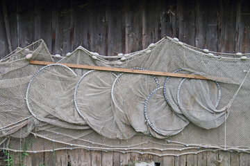 Fishing nets hang to dry near a boathouse on the lake