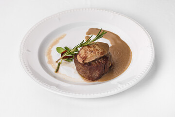 Fine cuisine on a white plate on a white background. Author's cuisine