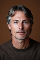 Fototapeta premium Mature man with silver hair and thoughtful look against dark backdrop