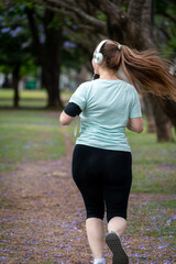Mujer entrenando y trotando de espaldas en un parque urbano en un hermoso día soleado. Mujer 
...