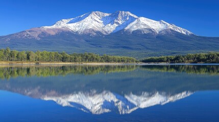 Naklejka premium Snow capped mountain reflected in a calm lake