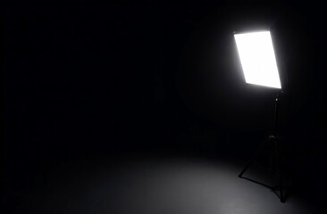 Studio lighting in a black studio, beam of light from professional lamps. Black studio background illuminated by white lighting sets.