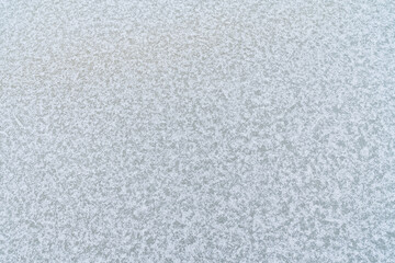 Ice texture with white snowflakes. Frozen water, winter background, abstract pattern.