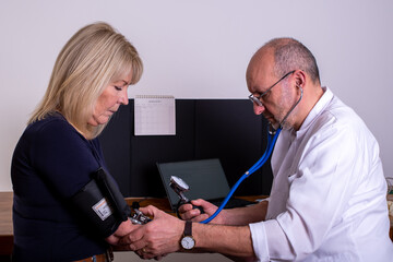 Blood pressure examination. A Dr checks observations at a routine appointment whilst in chatting...