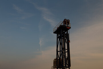 A silhouette of a pumping unit working in the evening