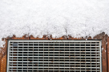 The threshold of the door is partially covered with snow in winter. A scraper for cleaning shoes...