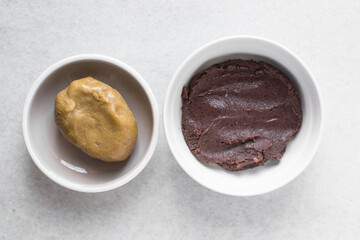 Overhead view of mooncake dough and red bean paste in a white plate, top view of mooncake dough and sweet adzuki bean paste in a white plate, process of making mooncakes