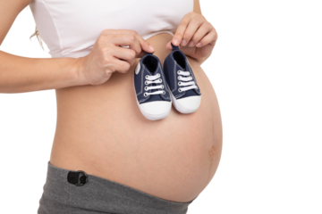 Pregnant woman holding baby shoes over her belly, symbolizing motherhood and joy