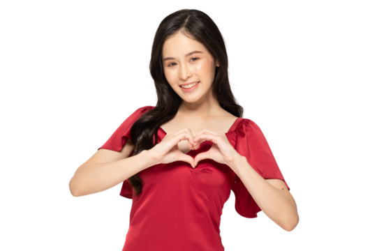 Smiling woman in red dress making heart gesture with her hands
