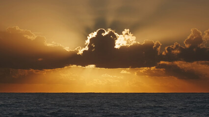 Sunrise over sea with illuminating clouds