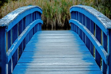 Obraz premium Wooden Bridge Pathway Leads to Tranquil Nature Scene, Blue Painted Wood Beams Arching Over Calm Water, Serene Outdoors Escape