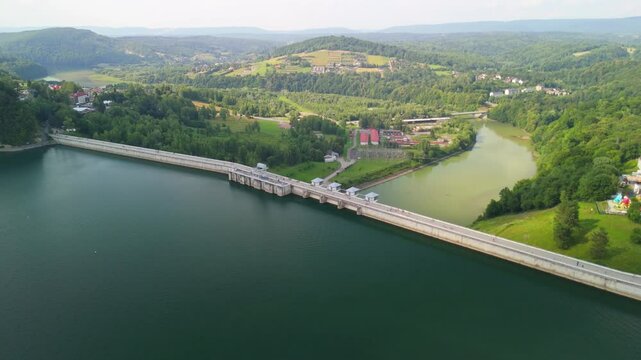 Solina dam with lush hills and boats docked near the shoreline.
