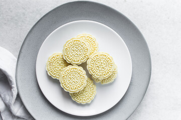 overhead view of tuwon madara on a white plate, nigerian alawar madara milk candy, top view of milk fudge on a white ceramic plate