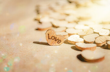 Wooden heart on kraft paper background with inscription love With sunlight and colored bokeh Copy space Wedding invitation card Valentine Defocused bokeh effect Front view