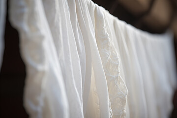 Obraz premium Delicate White Fabrics Draped on a Clothesline in Soft Natural Light, Showcasing Textures and Elegance for Home Decor Enthusiasts