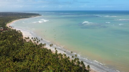Vue aérienne panoramique d’une plage en bord de mer avec eau turquoise et bateau
