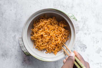 Overhead view of Spicy instant noodles in a claypot, spicy ramen noodles in a donabe