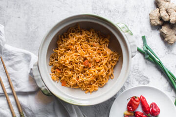 Overhead view of Spicy vegetable instant noodles in a claypot